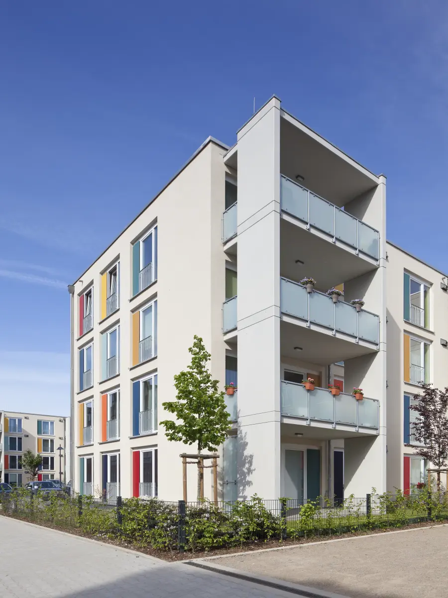 Gebäude mit weißen Fassaden und bunten Fensterrahmen