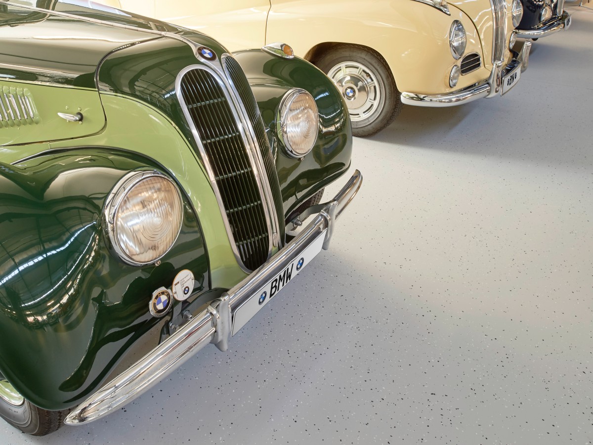 Alte Oldtimer stehen auf einem beschichteten Boden mit Dekoships