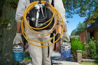 Maler trägt zwei Dosen Isoprimer mit Spraypack auf dem Rücken