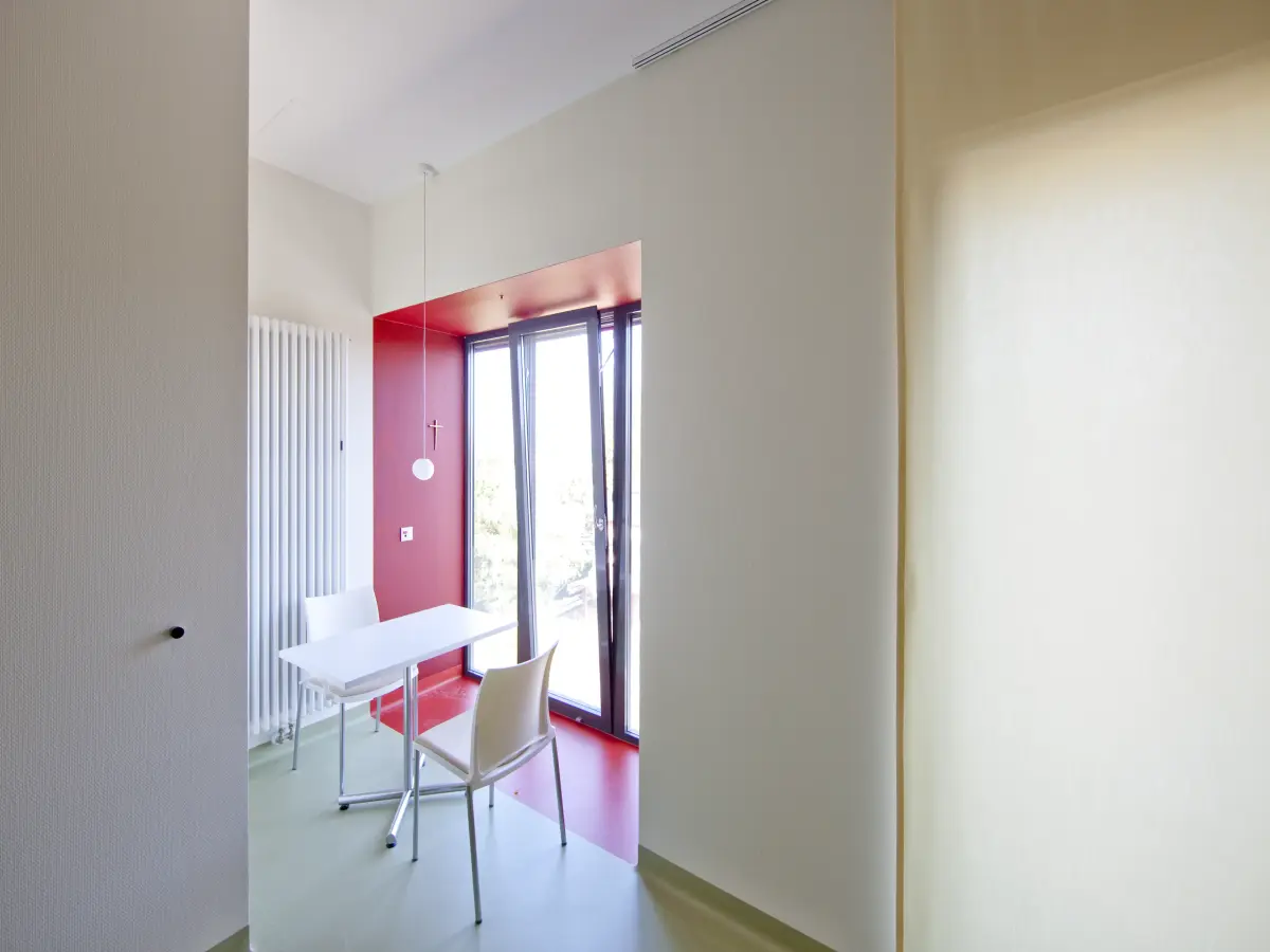 ein Zimmer in einem Krankenhaus mit weißen und rosa Wänden