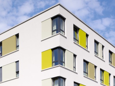 Ein Haus mit Fenstern, weißer Fassade und gelben Aussparungen