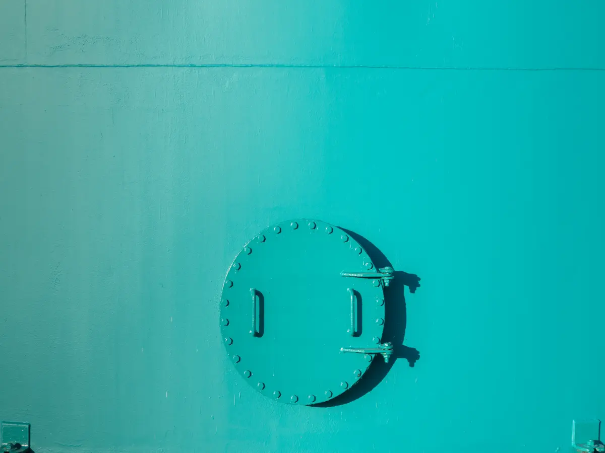 Türkislackierte Metallfläche mit Luke