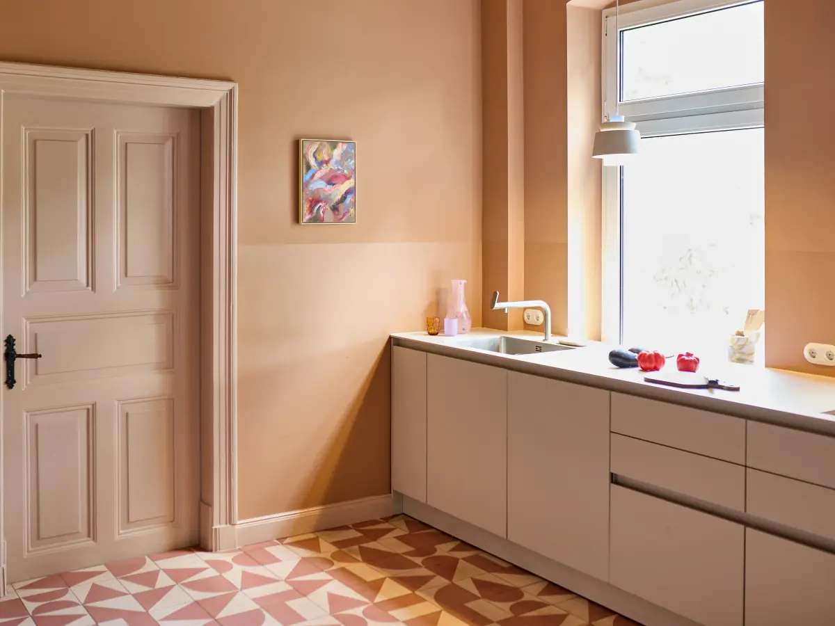 Weiße Küche mit cremefarbener Wand im Hintergrund