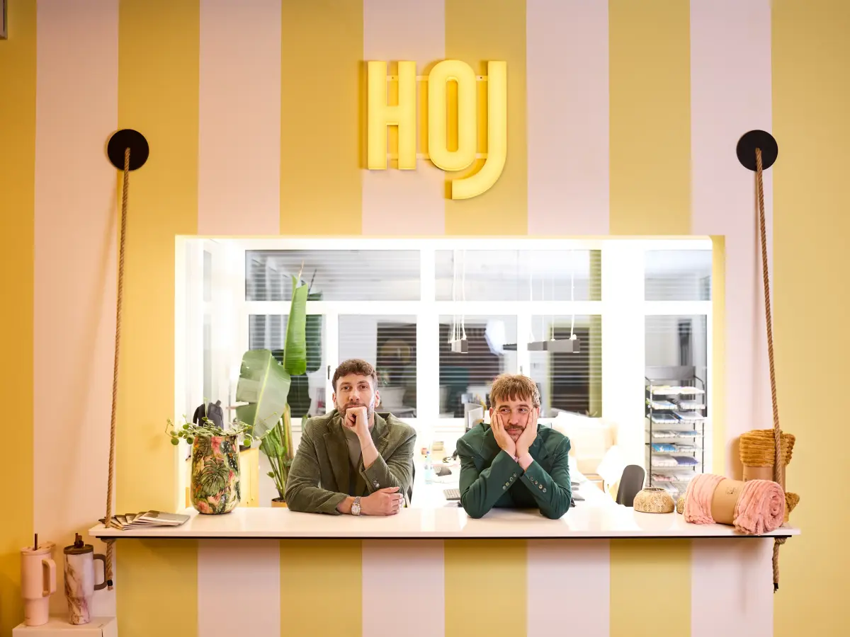 Michael und Christof lehnen auf einem Thresen und schauen in die Kamera