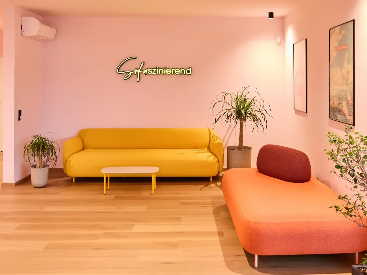 Bunte Sofas vor rosafarbener Wand