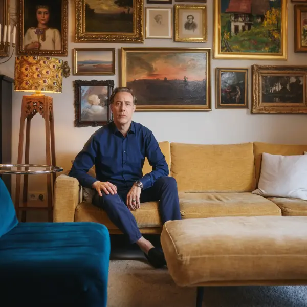 Jakob Bader lehnt an einem orangefarbenen Esstisch