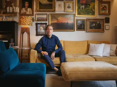 Jakob sitzt auf einem senfgelben Sofa und schaut mit ernstem Blick in die Kamera.