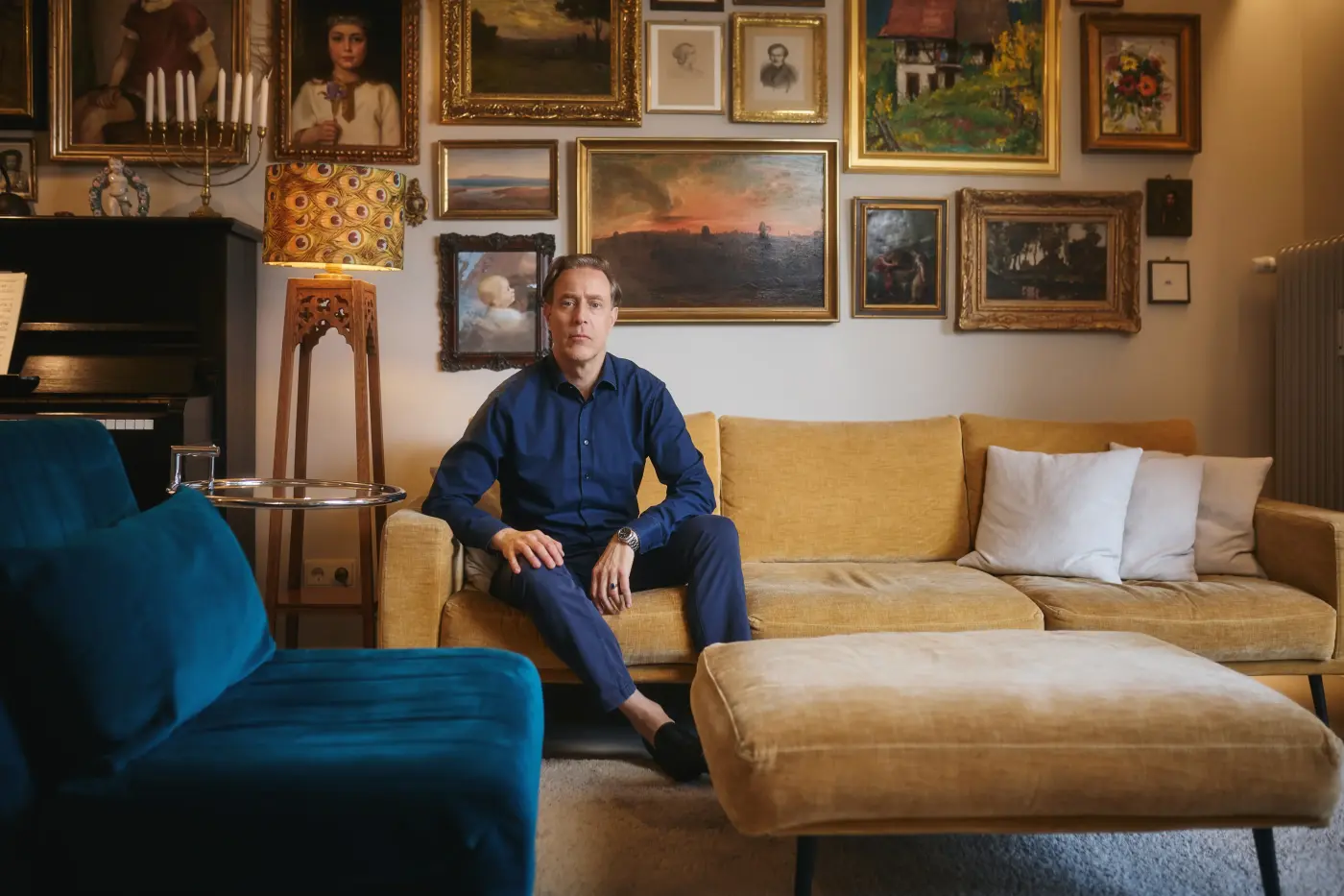 Jakob sitzt auf seinem Sofa und schau in die Kamera