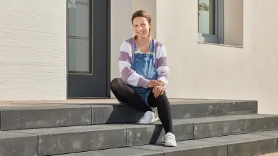 Anja sitzt auf den Stufen vor der Haustür