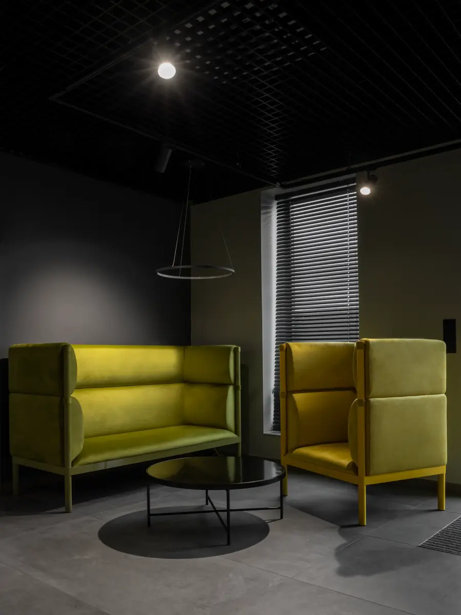 Sesselecke mit dunklem Hintergrund und grünen Sesseln