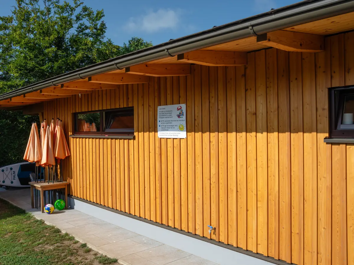 Holzhaus mit Stand-Up-Padel im Hintergrund 