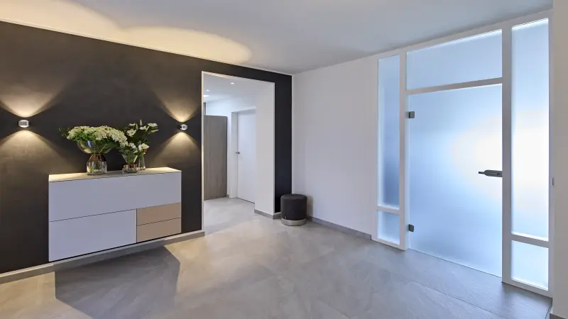 Eingangsbereich mit schwarzer Wand und Glastür