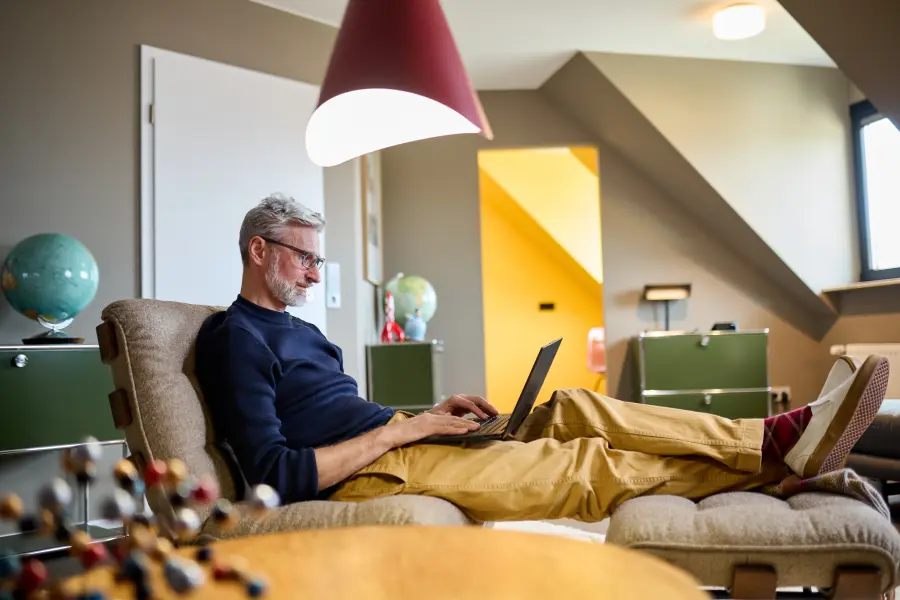 Matthias sitzt mit seinem Laptop auf dem Sofa