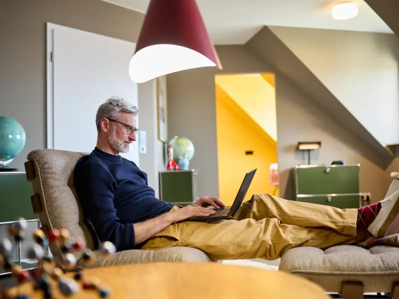 Matthias sitzt mit einem Laptop auf der Couch
