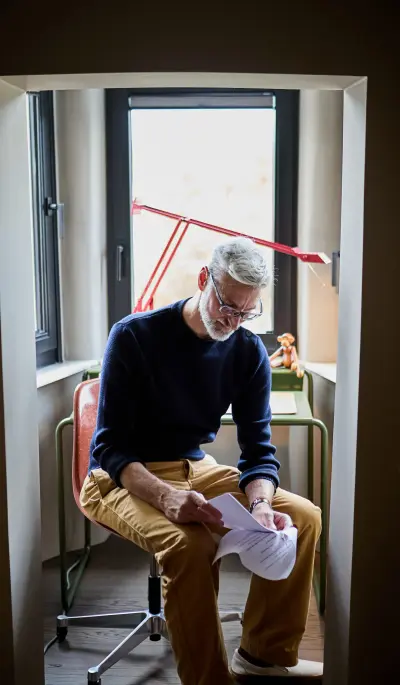 Mann sitzt auf Stuhl und liest