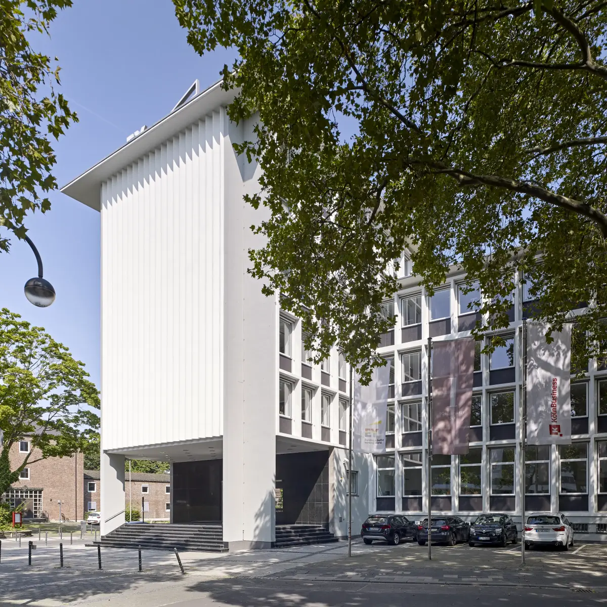 Gebäude Sichtbetonfassade mit Parkplatz im Vordergrund