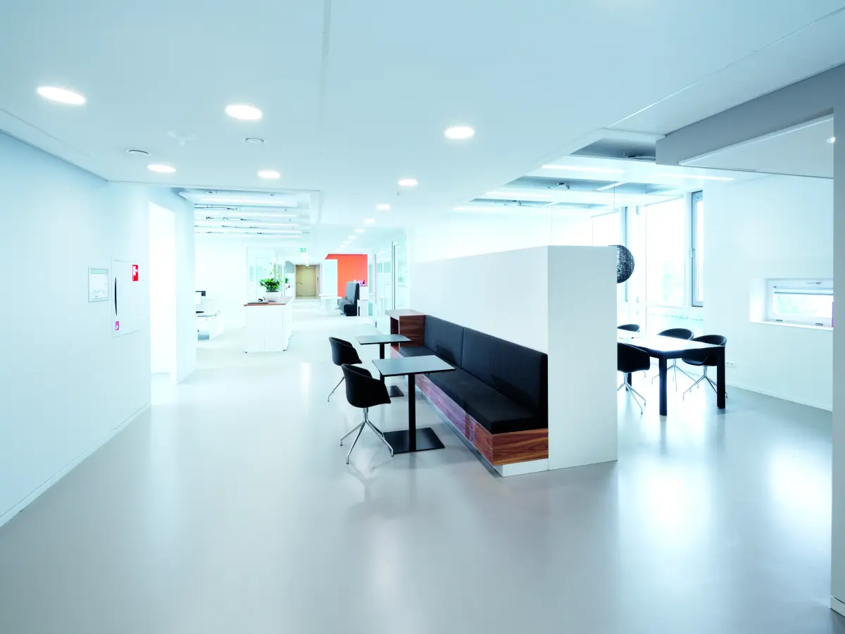 Weiße Raumtrennwand mit eingelassener Sitzecke