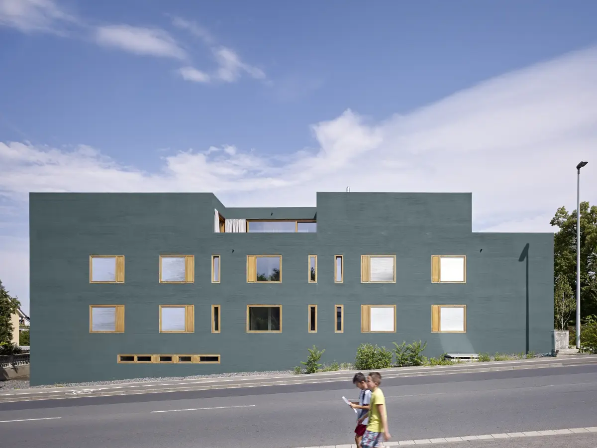 ein Gebäude mit einer grünen Fassade und gelben Fensterrahmen