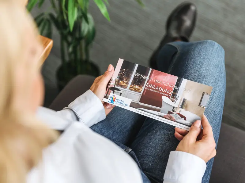 Frau hält Flyer auf dem Schoß in der Hand