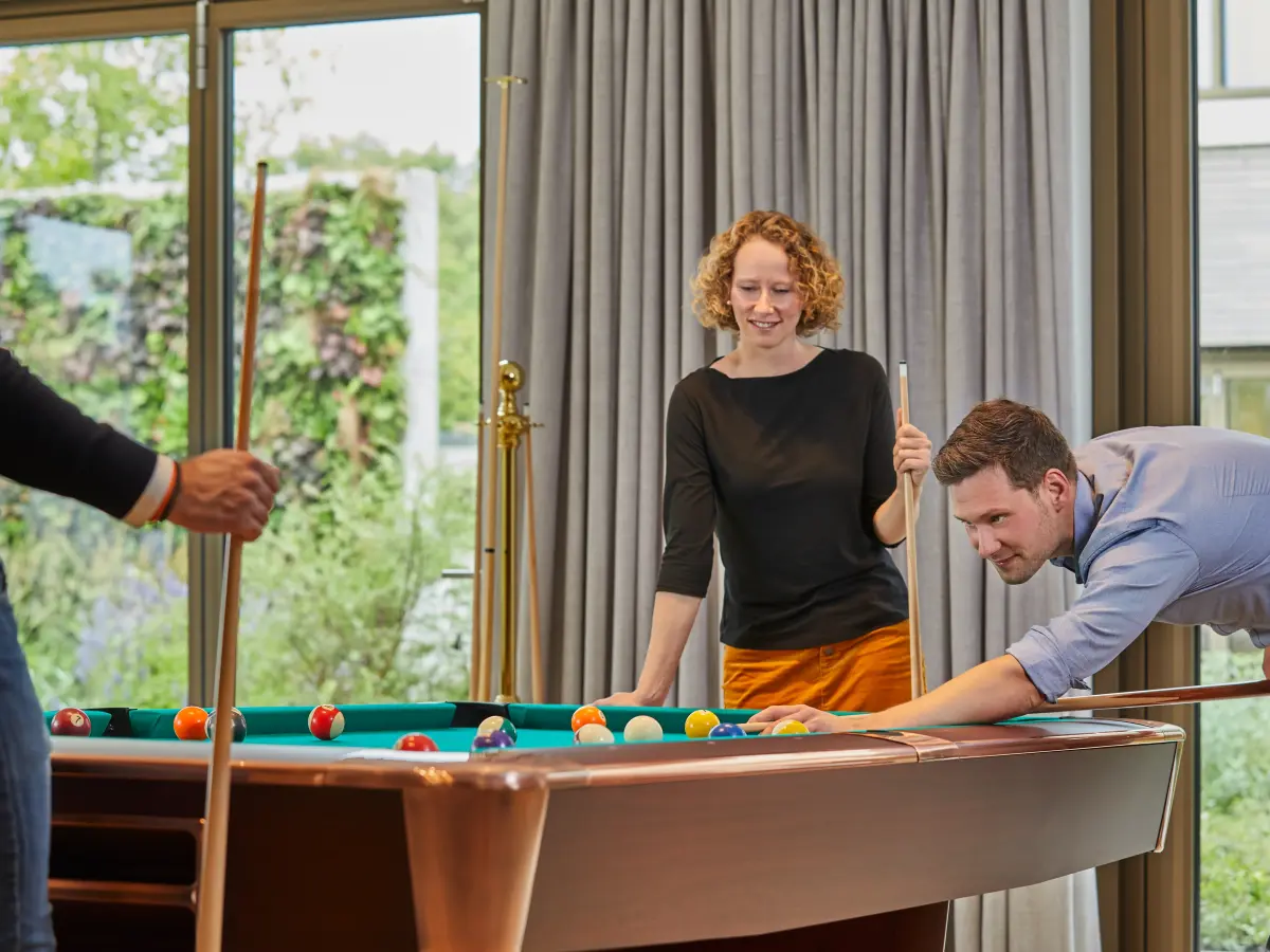 Gruppe von Leuten spielt zusammen Billard