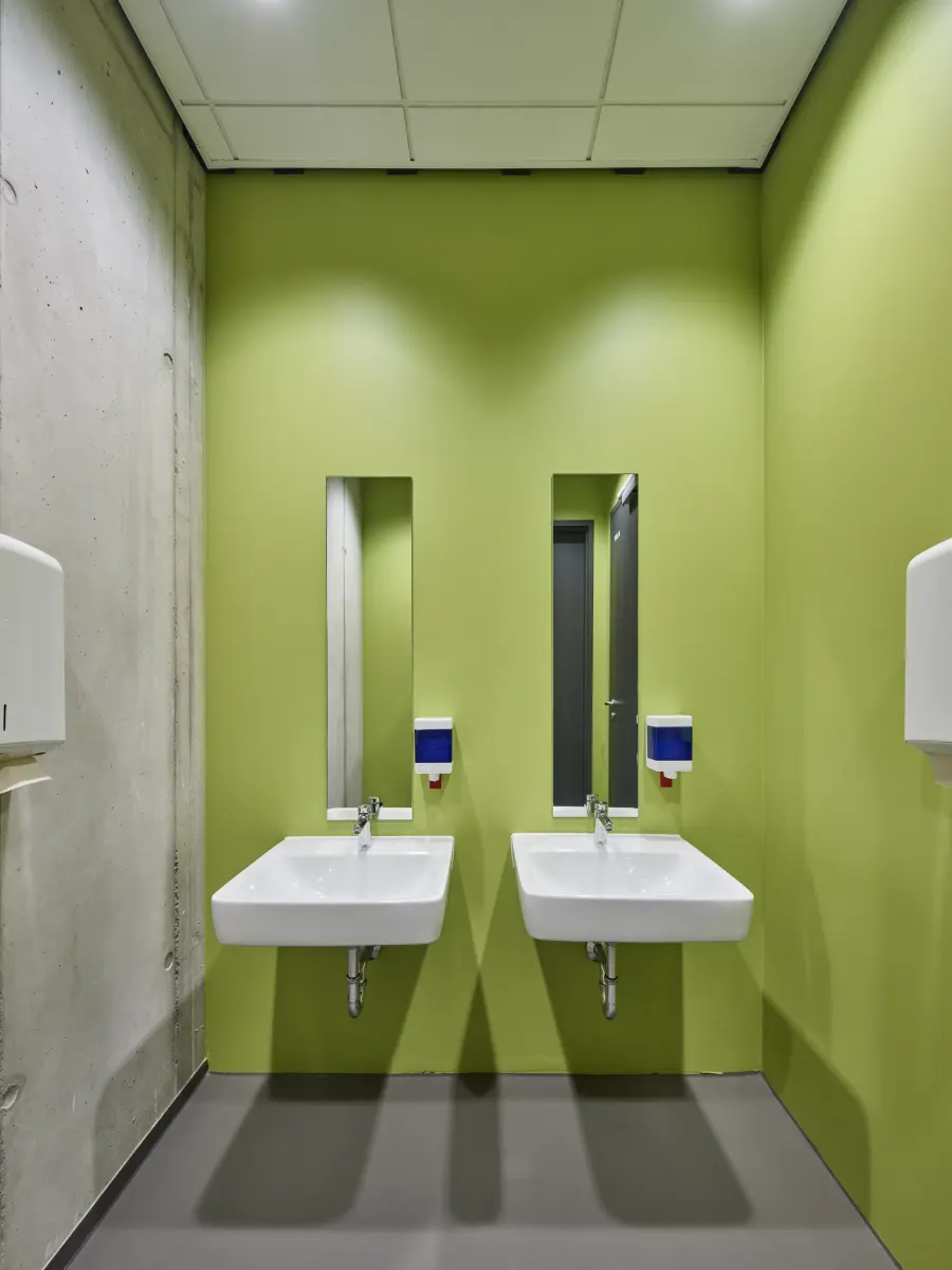 Toilettenbereich Blick auf Wand mit Wasserhahn und Spiegel mit Grüner Wand