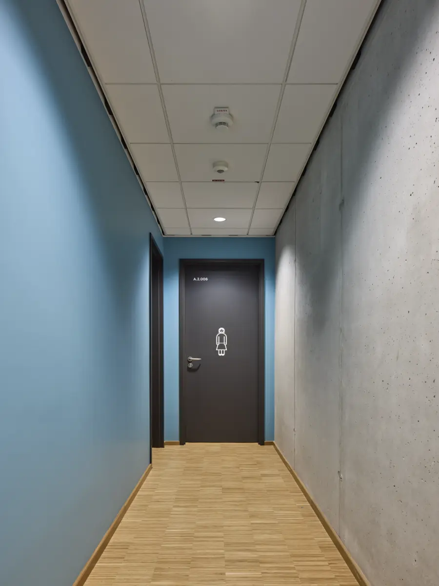 Flur zum Frauen-WC mit blauer Wand