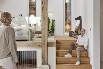 offenes Wohnzimmer mit Holztreppe und zwei Personen 