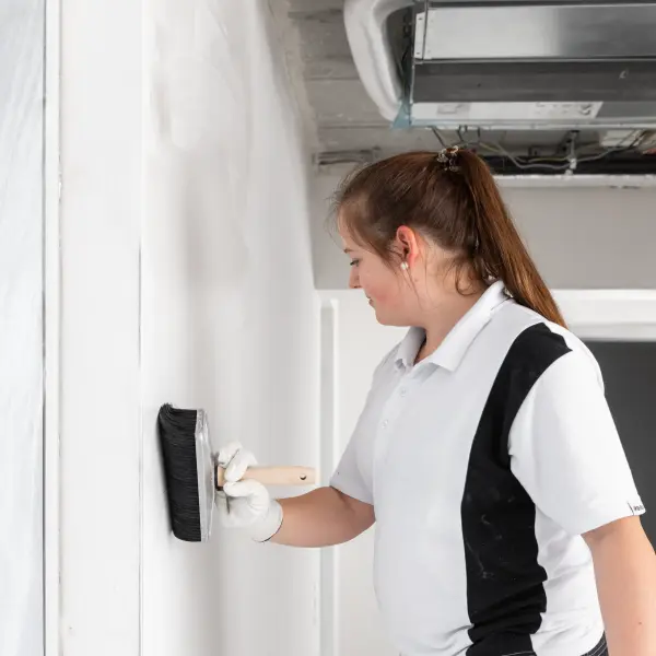 Malerin spachtelt Wand