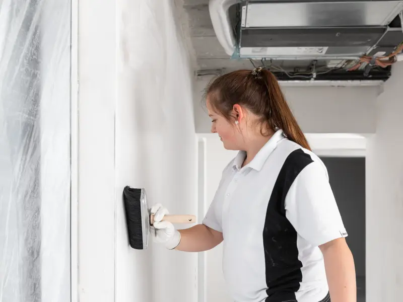 Malerin spachtelt Wand