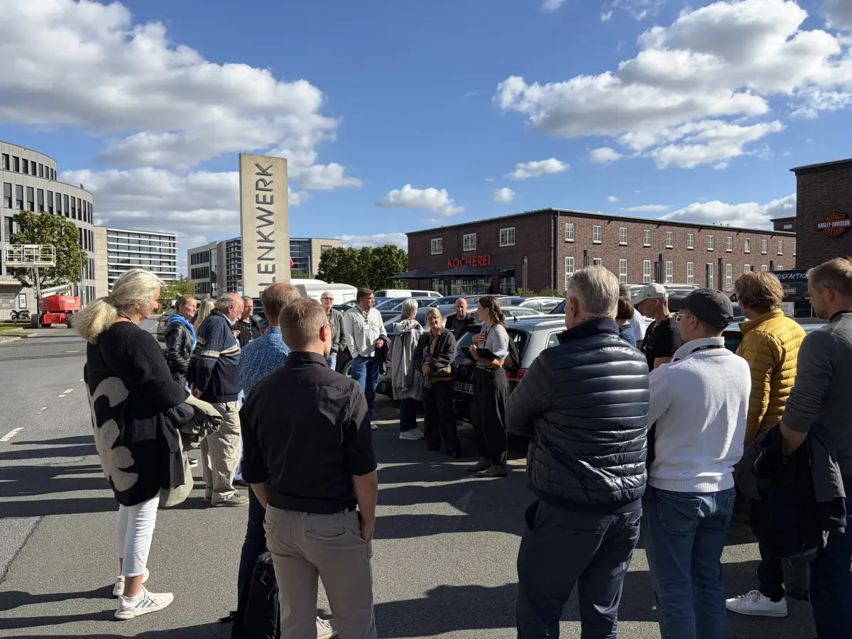 Eine Personengruppe vor einem Industriegebäude