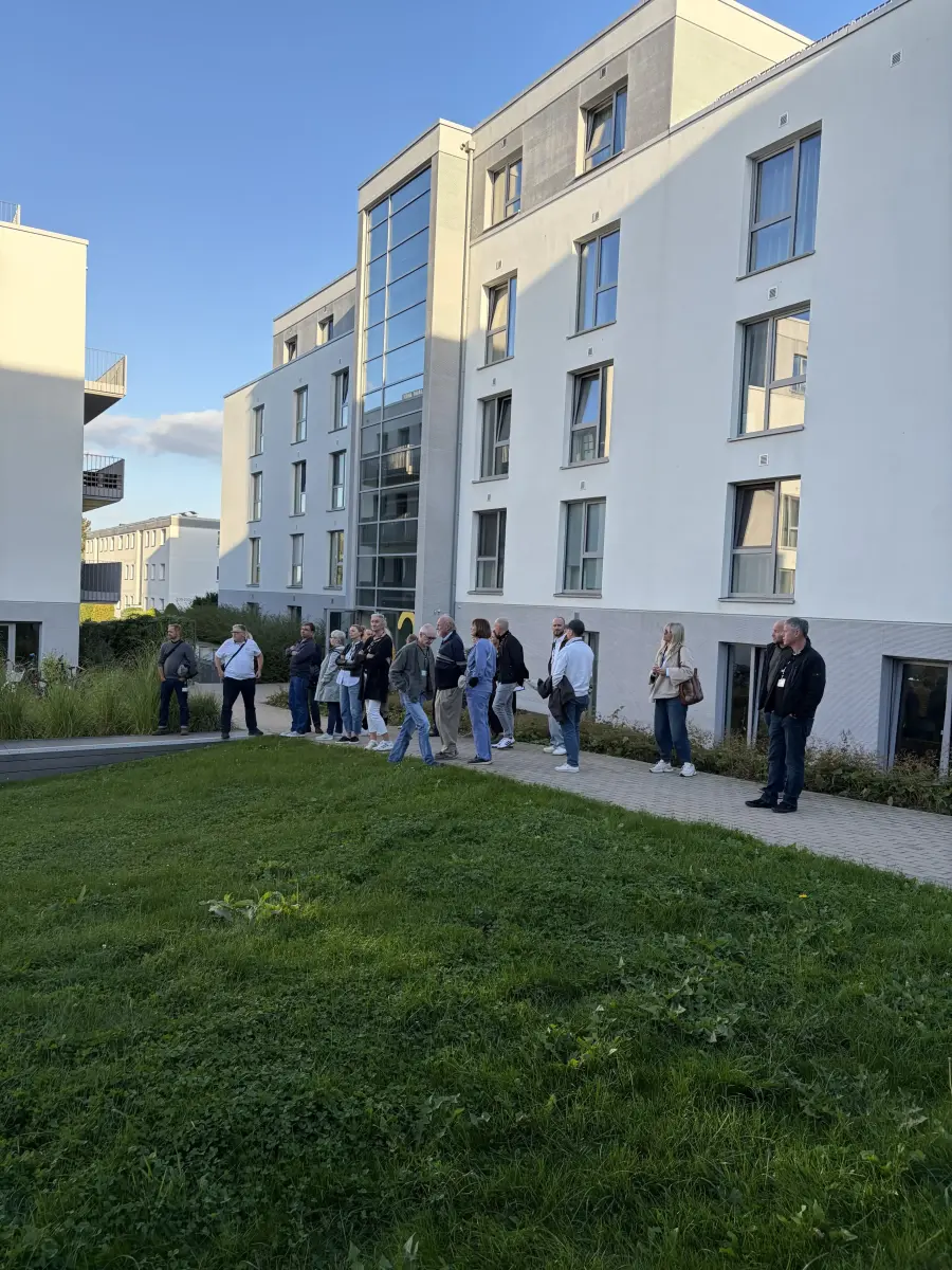Eine Personengruppe vor einem weißen Gebäude