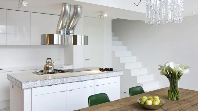 moderne offene Küche mit Esstisch und Treppe in die obere Etage