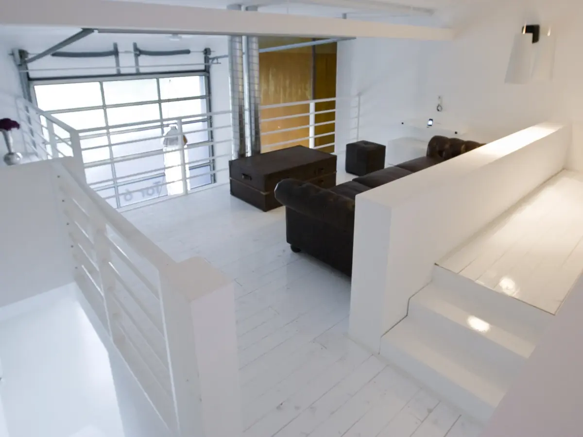 obere Etage mit schwrzer Sofaganitur und Tisch