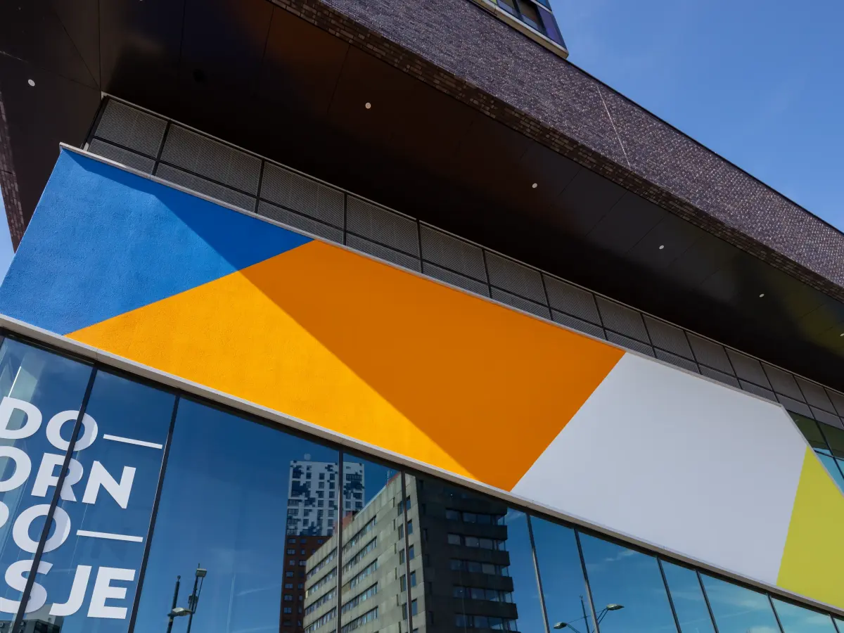 Fassade mit viel Glas und orangefarbenen Elementen