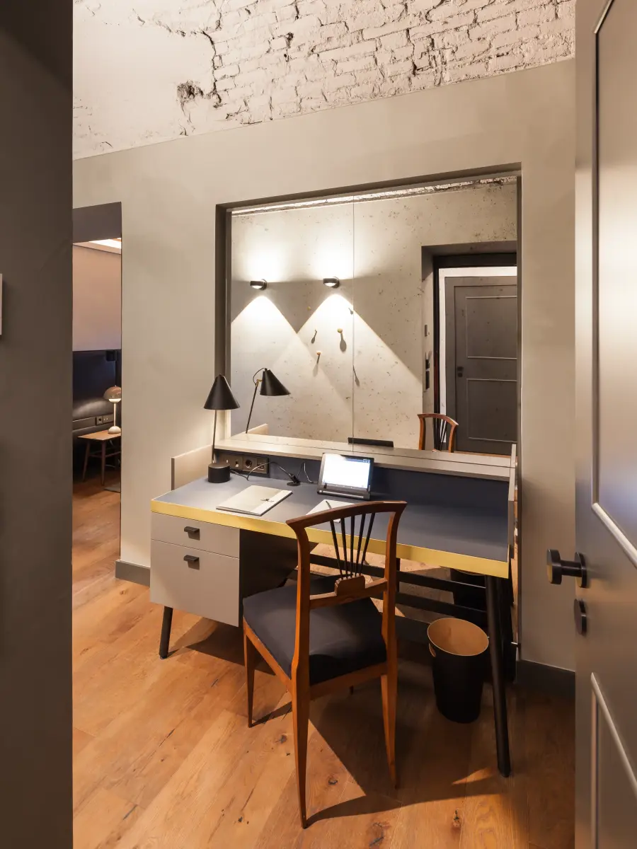 Blick in ein Zimmer mit Schreibtisch und Spiegel