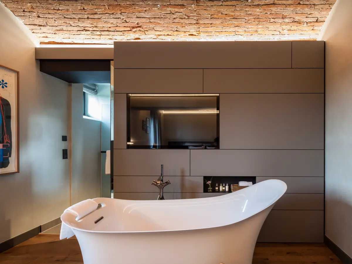 Badezimmer mit fristehender Badewanne und rustikaler Decke