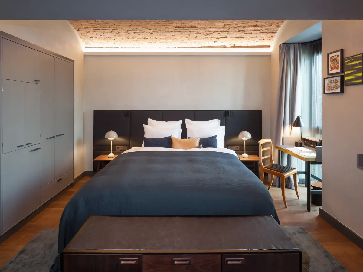 Hotelzimmer mit Doppelbett und kleinem Schreibtisch