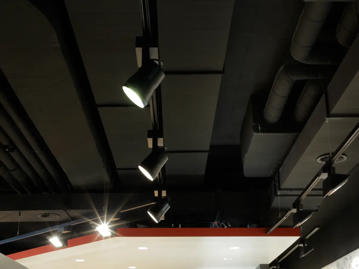 Deckengestaltung mit dunklem Industrial-Design und modernen Strahlern in der Bäckerei Brot & Co.