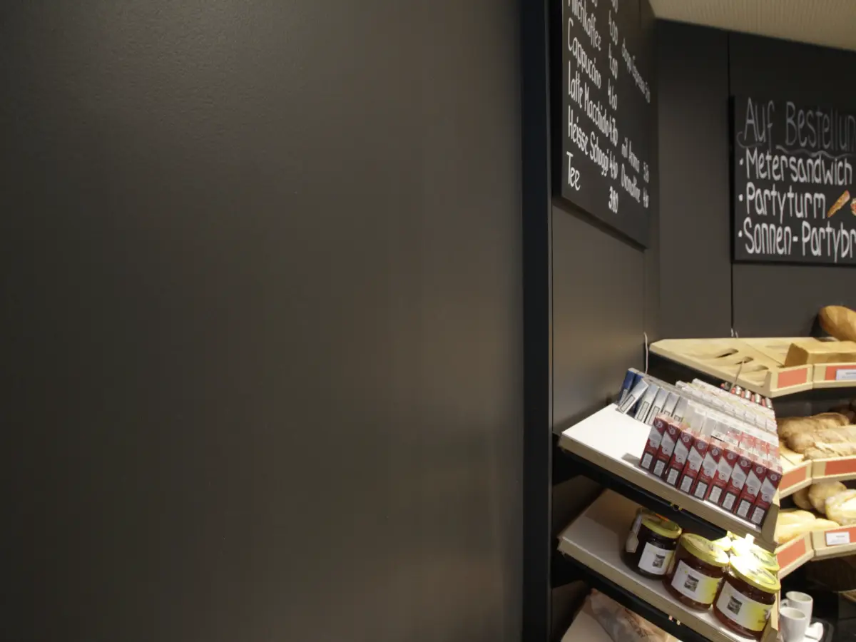 Detailansicht der modernen Innenfassade in der Bäckerei Brot & Co, kombiniert mit Regalen für Produkte.