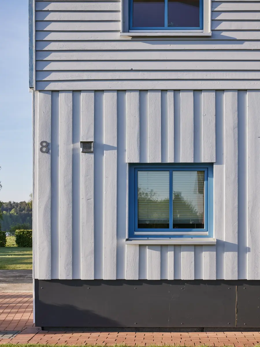 Weiße vertikale Holzlatten mit blauem Fenster