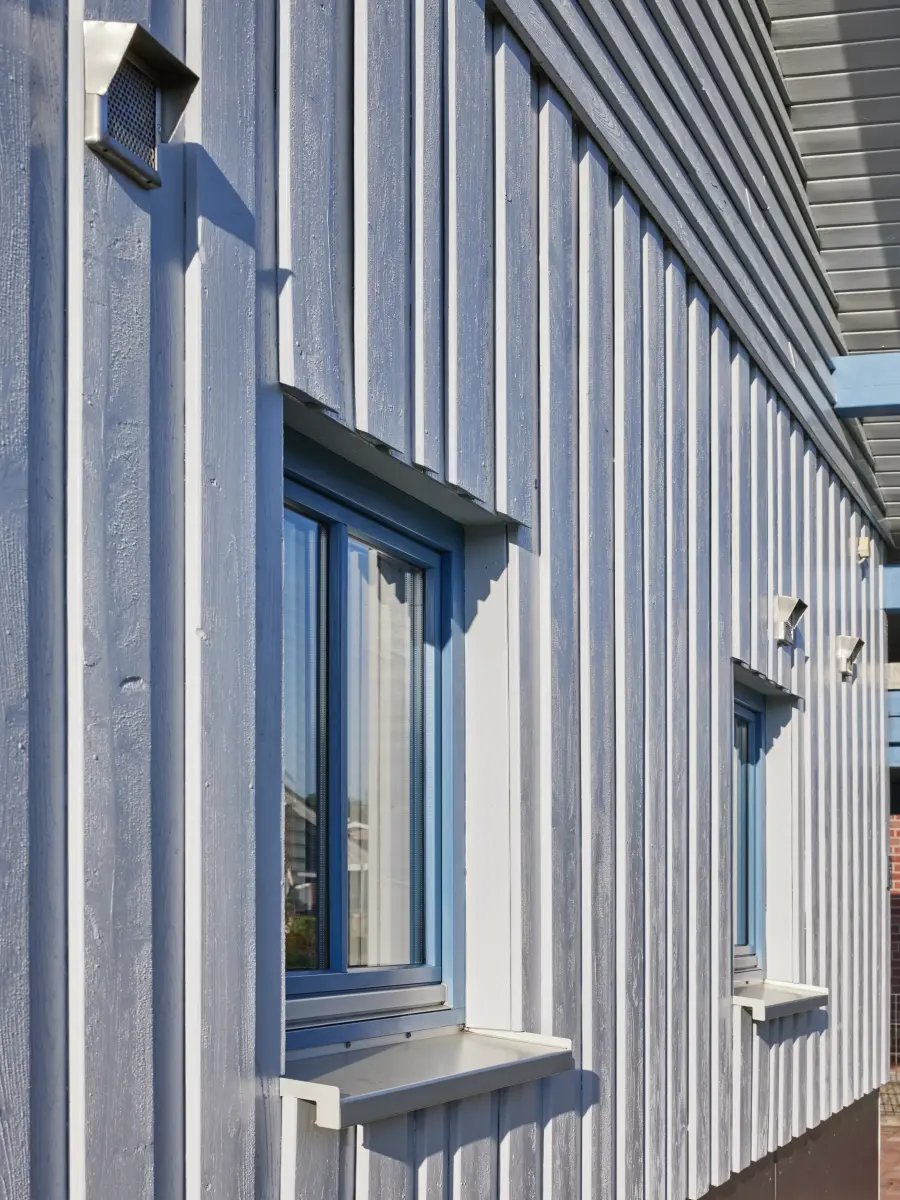 Weiße vertikale Holzlatten mit blauen Fenster
