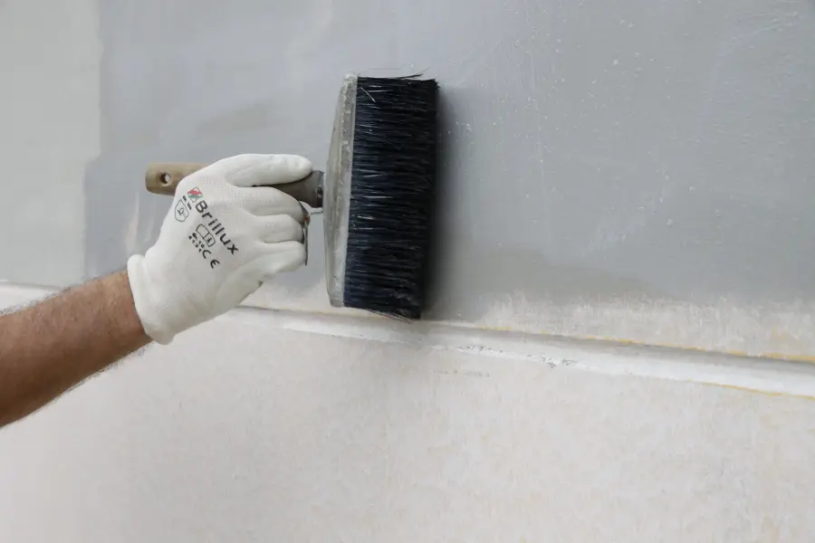 Ein Pinsel malt auf eine Wand