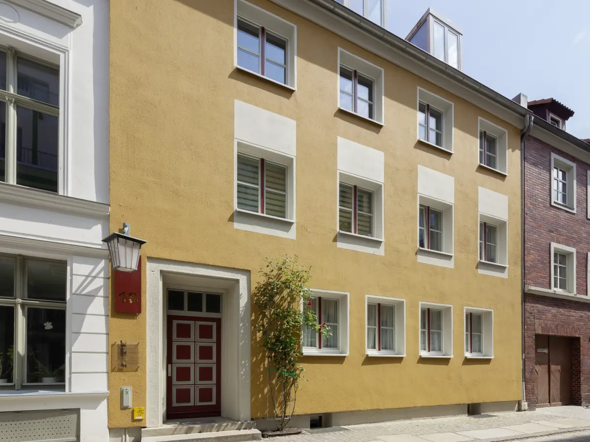 feinen Akzenten in Dunkelrot mit Tür und Stulpfenstern