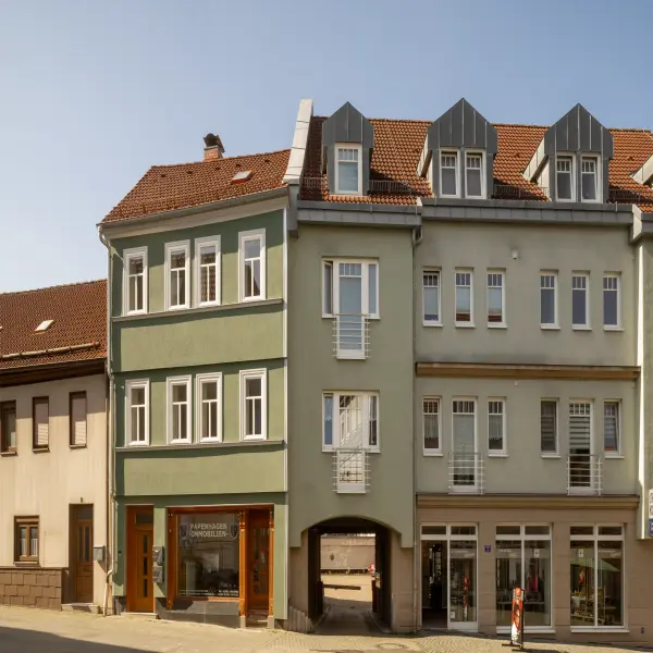 Grüne Fassade und orangene Dachziegel