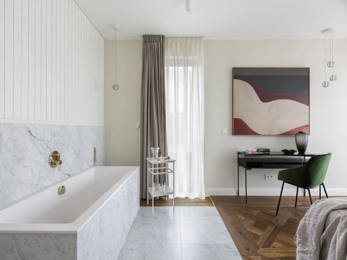 Helles Schlafzimmer mit Badewanne und Schreibtisch