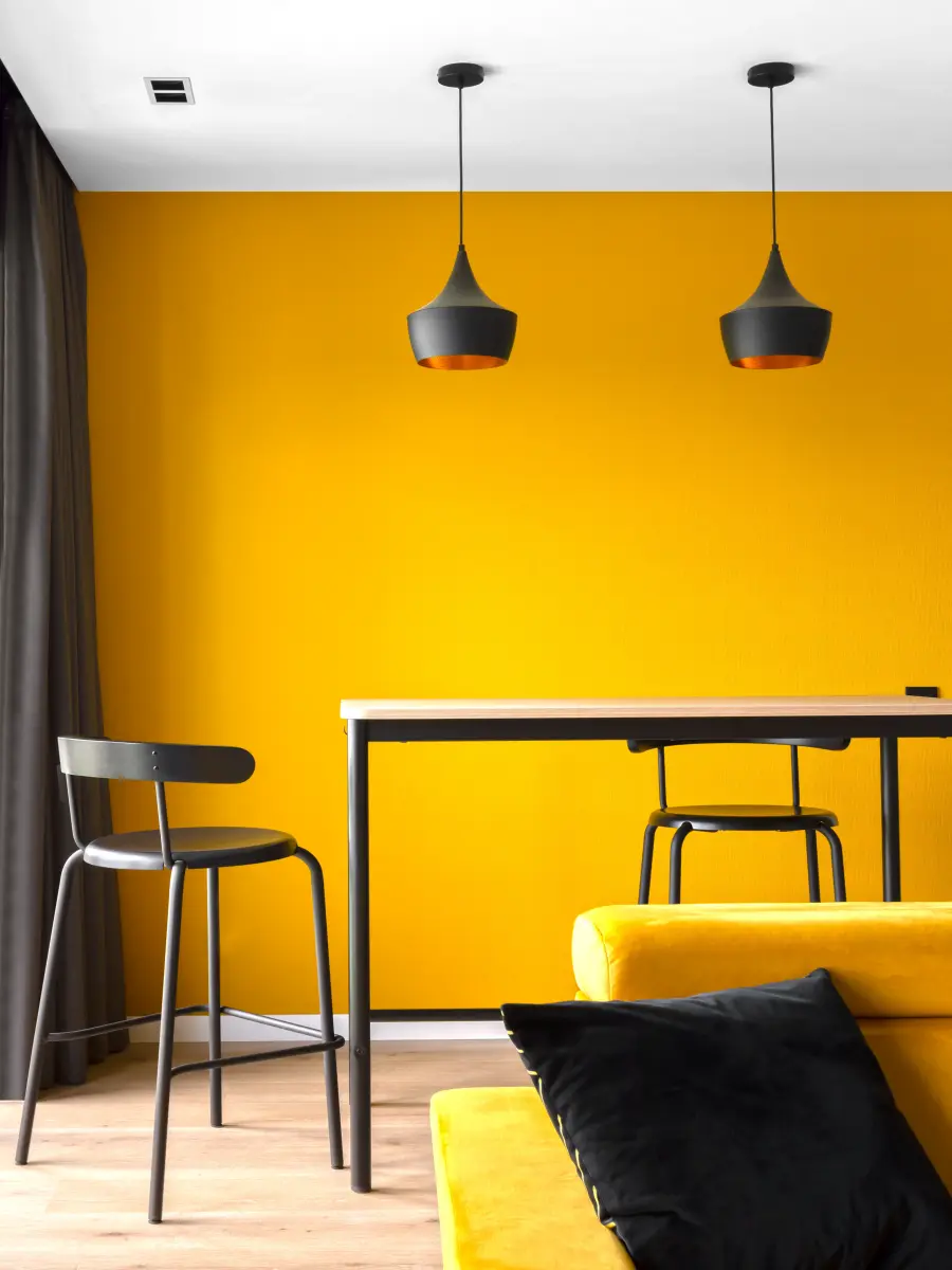 Hoher Tisch vor gelber Wand