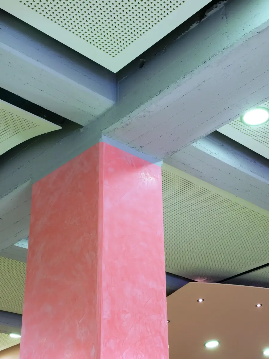 Mittelstützen in weichem Terracotta gliedern den Raum