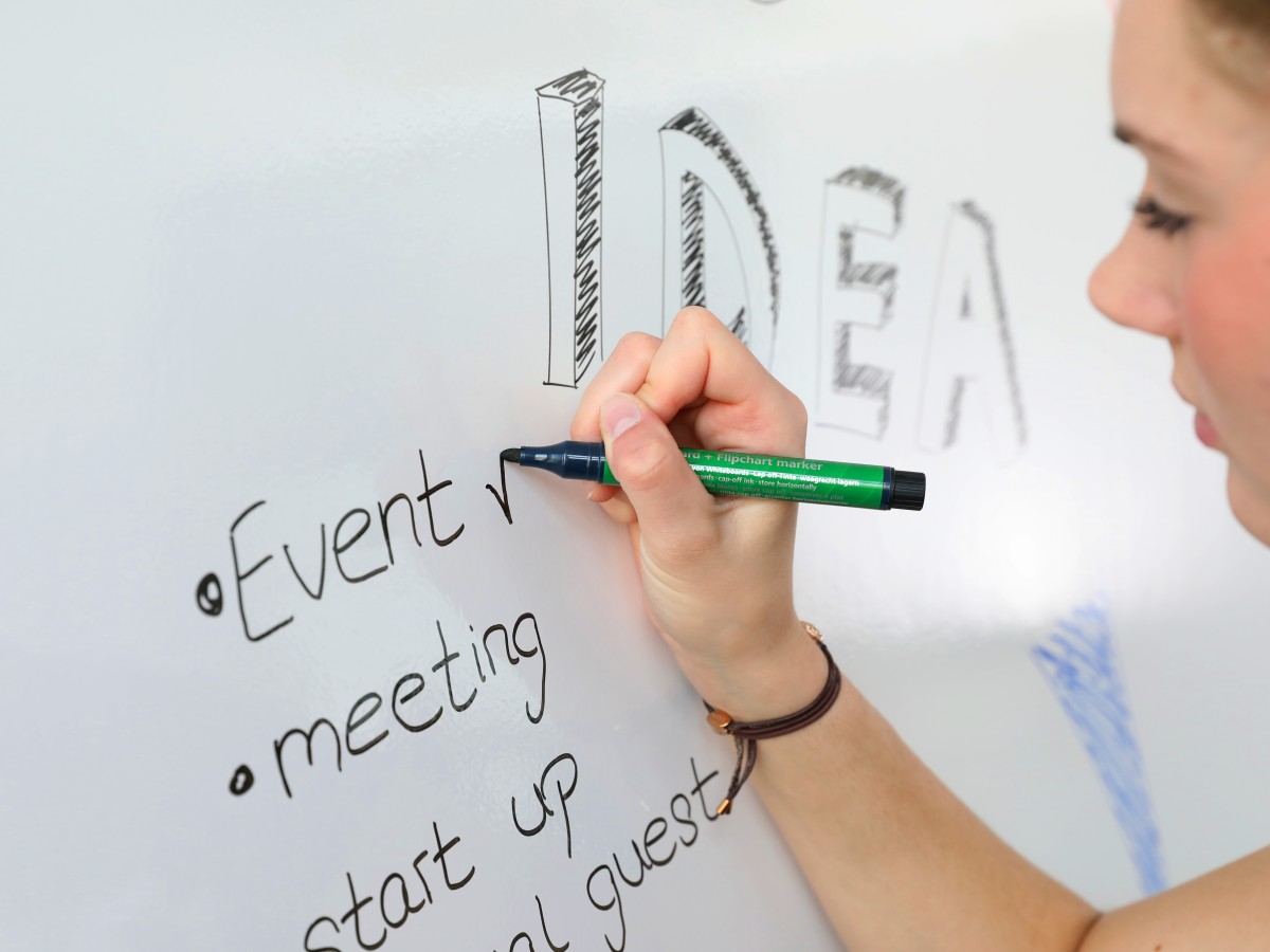 Person schreibt auf Whiteboard