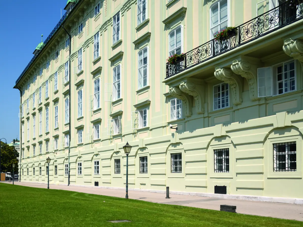 ein historisches Gebäude mit gelben Wänden und rotem Dach