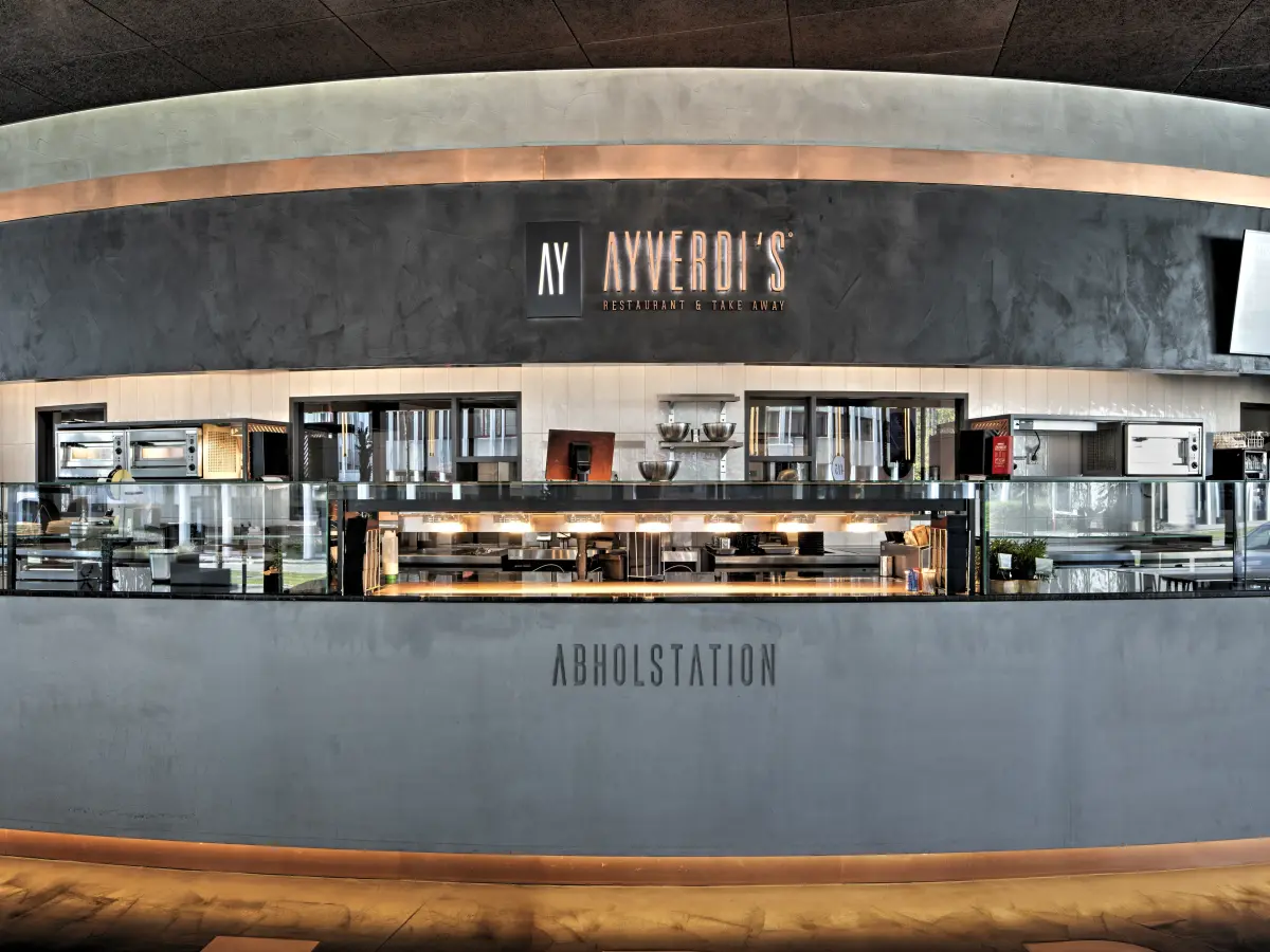 Moderne Abholstation in einem Restaurant mit Theke und Küchenbereich.